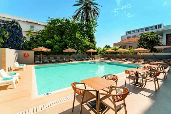 Ulkouima-allas, jonka ympärillä on aurinkotuoleja ja päivänvarjoja sekä etualalla pöytiä ja tuoleja. (Tekoälyn luoma teksti)