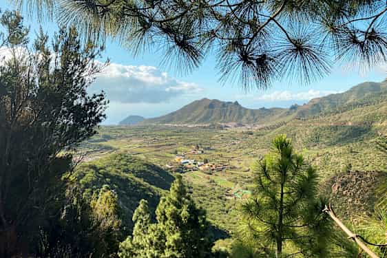 Näkymä vihreään laakson alueeseen, jossa on kyliä ja vuoria taustalla. (Tekoälyn luoma teksti)