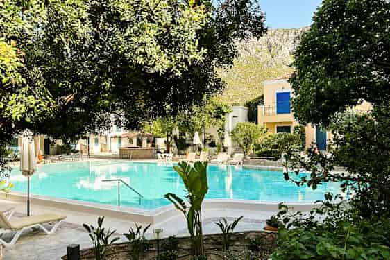 Kuva altaasta, jota ympäröivät puut ja aurinkotuolit. (Tekoälyn luoma teksti)