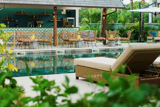 Kuva uima-allasalueesta, jossa on aurinkotuoleja ja baari taustalla. (Tekoälyn luoma teksti)