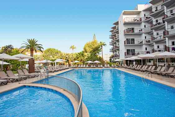 Suuri uima-allas, jota ympäröivät aurinkotuolit ja aurinkovarjot hotellin yhteydessä. (Tekoälyn luoma teksti)