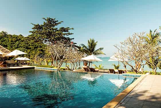 Infinity-allas rannalla, taustalla aurinkotuoleja ja aurinkovarjoja. (Tekoälyn luoma teksti)