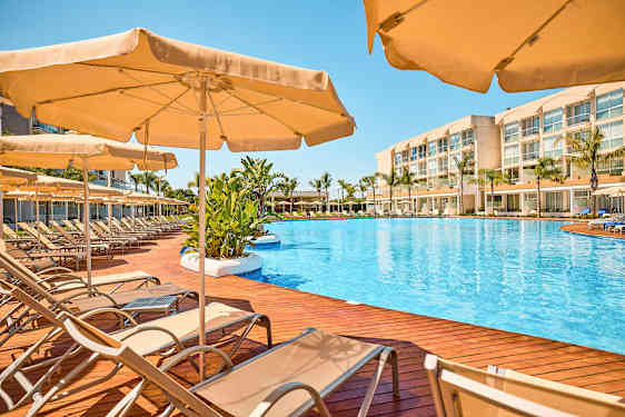 Uima-allasalue, jossa aurinkotuoleja ja aurinkovarjoja puuterassilla. (Tekoälyn luoma teksti)