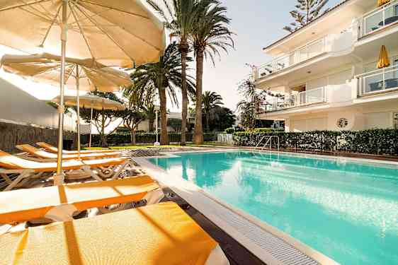 Ulkouima-allas aurinkotuoleilla ja -varjoilla aurinkoisessa säässä. (Tekoälyn luoma teksti)