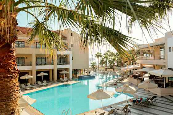 Hotelli, jossa ulkouima-allas, aurinkotuoleja ja varjoja. (Tekoälyn luoma teksti)