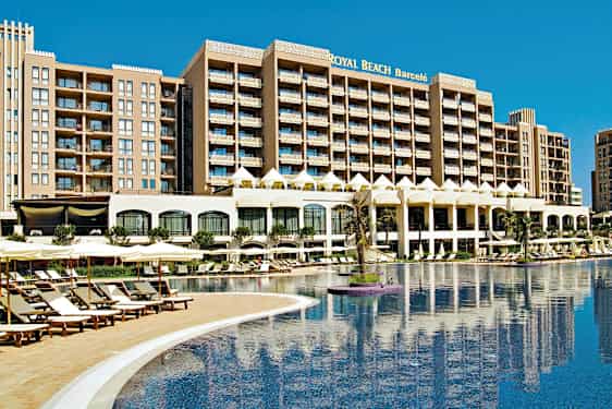 Usean kerroksen hotelli suuren altaan äärellä, jota ympäröivät aurinkotuolit ja aurinkovarjot. (Tekoälyn luoma teksti)