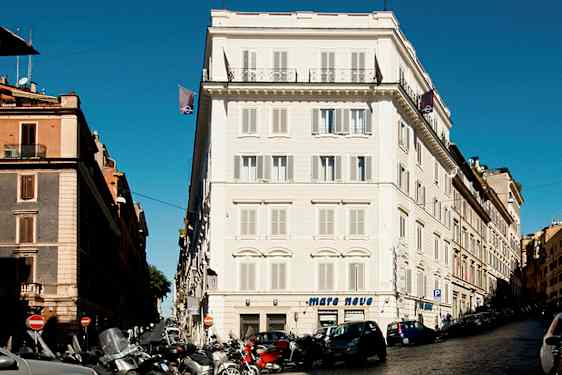 Katu, jossa autoja ja moottoripyöriä rakennusten edessä kaupunkialueella. (Tekoälyn luoma teksti)