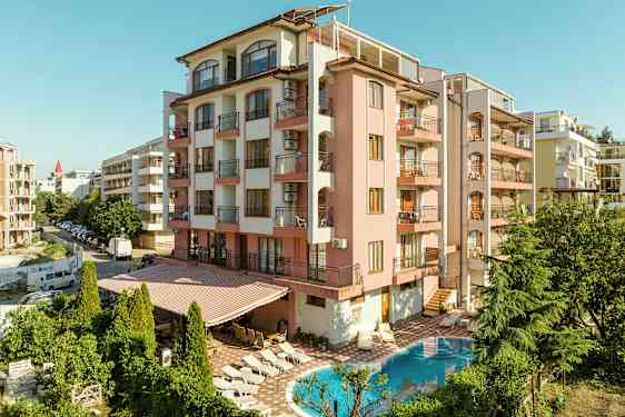 Vaaleanpunainen julkisivuinen rakennus, parvekkeita ja uima-allas edessä. (Tekoälyn luoma teksti)