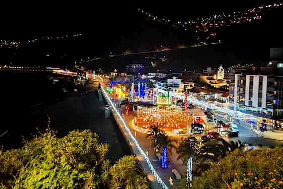 Kaupunki meren rannalla yöllä valaistuksineen ja koristeluineen. (Tekoälyn luoma teksti)