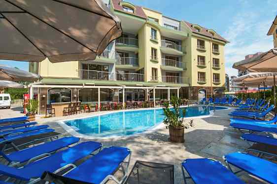 Kuva hotellialueesta, jossa on uima-allas, aurinkotuoleja ja rakennus. (Tekoälyn luoma teksti)