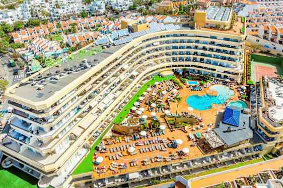 Kuva hotellista, jossa on uima-allasalue ja sitä ympäröiviä lomamajoja. (Tekoälyn luoma teksti)