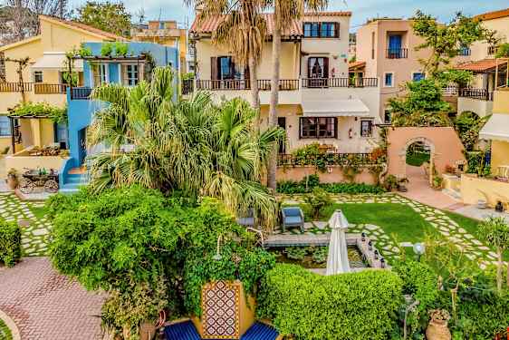 Viehättäviä taloja värikkäillä julkisivuilla, joita ympäröi vehreys ja kukat. (Tekoälyn luoma teksti)