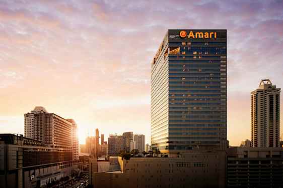 Kaupunki näkyy auringonlaskun aikaan, korkeita rakennuksia korostuu maisemassa. (Tekoälyn luoma teksti)