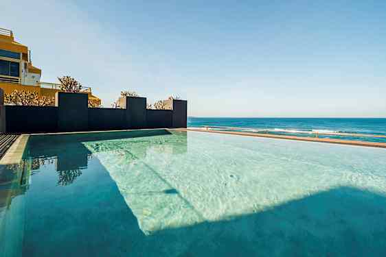 Infinity-allas, josta on näkymä merelle kirkkaan taivaan alla. (Tekoälyn luoma teksti)