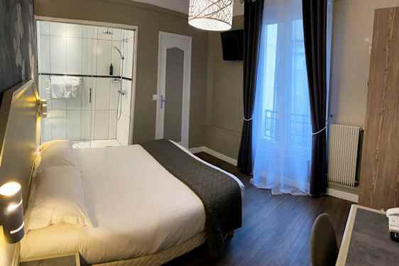 Hotellihuone, jossa sänky, työpöytä ja suihku. (Tekoälyn luoma teksti)