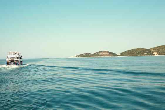 Vene liikkuu tyynellä merellä, ja horisontissa näkyy matalia saaria. (Tekoälyn luoma teksti)