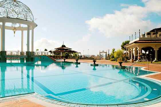 Ulkouima-allas, jossa koristeltu paviljonki ja ympärillä välimerellisiä rakennuksia. (Tekoälyn luoma teksti)