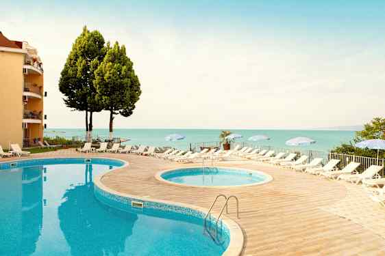 Kaksi uima-allasta aurinkotuoleilla ja varjoilla paikan lähellä merta. (Tekoälyn luoma teksti)