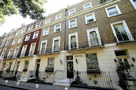 Kuva Queensway-hotellista, jossa on tiiliseinä ja parvekkeet. (Tekoälyn luoma teksti)