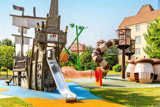 Leikkikenttä, jossa laiva ja liukumäkiä. (Tekoälyn luoma teksti)