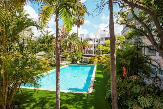 Ulkouima-allas, jonka ympärillä on palmuja ja rakennuksia. (Tekoälyn luoma teksti)