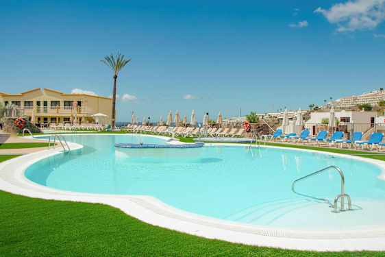 Hotellin uima-allas, ympärillä aurinkotuoleja ja -varjoja. (Tekoälyn luoma teksti)