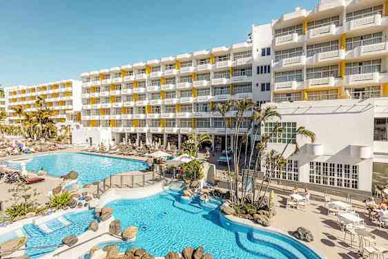 Hotellirakennus, aurinkotuoleja ja allasalue. (Tekoälyn luoma teksti)