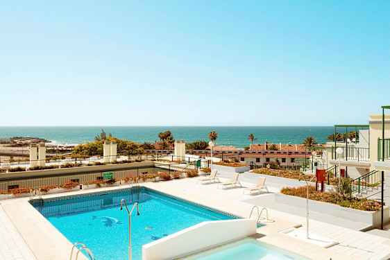 Kuva uima-altaasta ja aurinkoterassista, taustalla näkyy meri. (Tekoälyn luoma teksti)