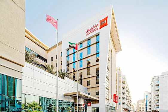 Hotellirakennus, jossa on "ibis Mall of the Emirates" -kyltit ja edessä lipputankoja. (Tekoälyn luoma teksti)