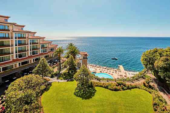 Kuva hotellista rannalla, merinäköala, allasalue ja aurinkotuoleja. (Tekoälyn luoma teksti)