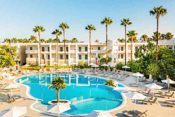 Uima-allasalue jossa aurinkotuoleja, varjoja ja hotellirakennuksia taustalla. (Tekoälyn luoma teksti)