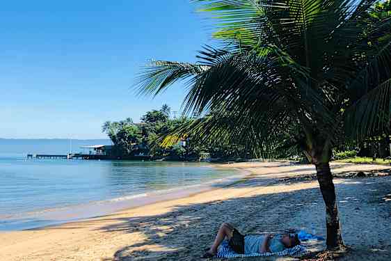 Jessica lepää palmujen varjossa rannalla