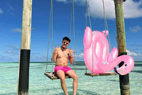 Käärijä keinumassa flamingo-uimalelun kanssa Kuredulla Malediiveilla