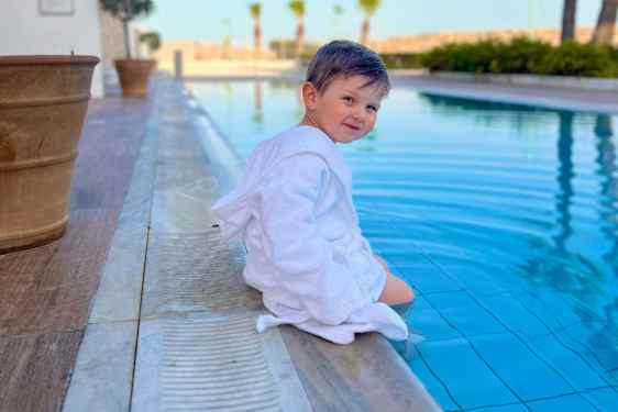 Lapsi kylpytakissa altaan reunalla