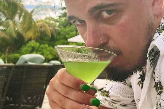 Käärijä nauttimassa vihreää drinkkiä Malediiveilla