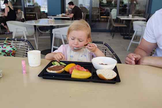 Pikkutyttö syö aamiaista