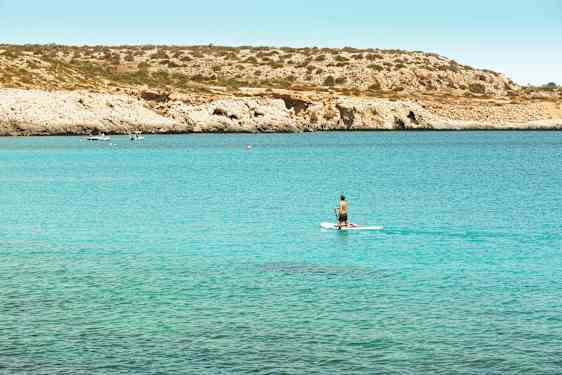 Sup-lautailija meloo sinisellä merenlahdella