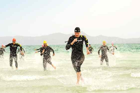 Triathlonistit juoksevat pois merestä