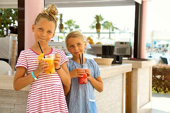 Kaksi lasta mehulasit käsissään