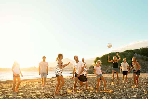 Perheitä pelaamassa rannalla