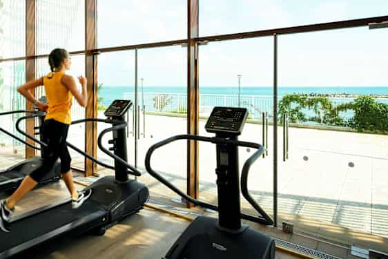 Nainen juoksumatolla hotellin kuntosalilla