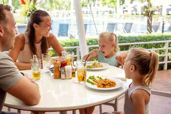 Isä, äiti ja kaksi tyttöä ruokailemassa