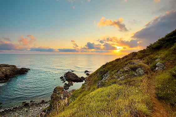 Auringonlasku rantakallioiden taakse