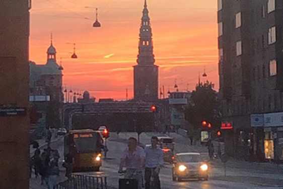 Pyöräilijöitä auringonlaskumaisemassa