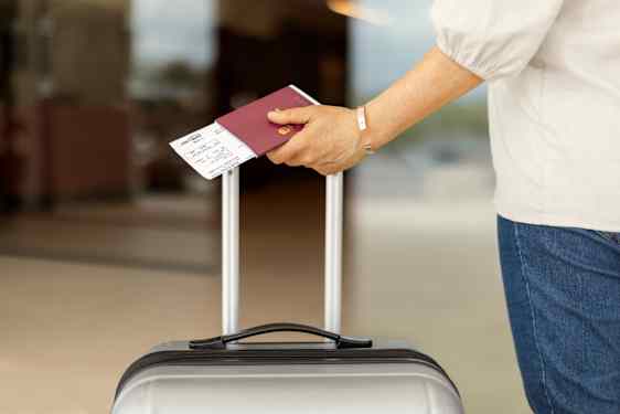Passi ja lentolippu matkustajan kädessä