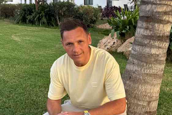 Joakim Hykkerud nojaamassa palmun runkoon