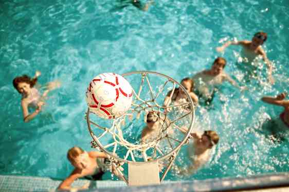 Nuoret pelaamassa vesipalloa uima-altaassa
