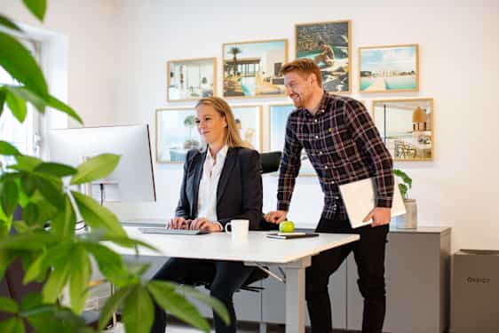 Kaksi henkilöä työpöydän ääressä toimistolla