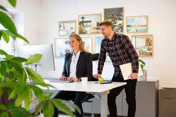 Toimistohenkilökunaa työpöydän äärellä