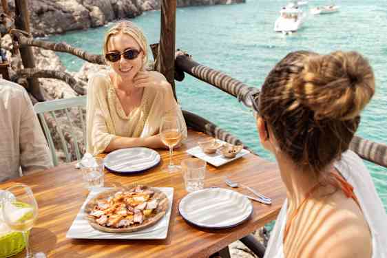 Ystävykset syömässä meren herkkuja